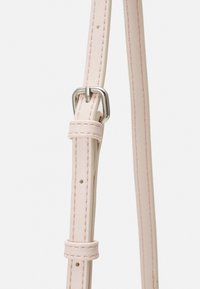 Cinturino in pelle rosa con fori per regolazioni multiple e componenti in metallo argentato. Caratterizzato da una texture liscia e un dettaglio di cuciture sottili.