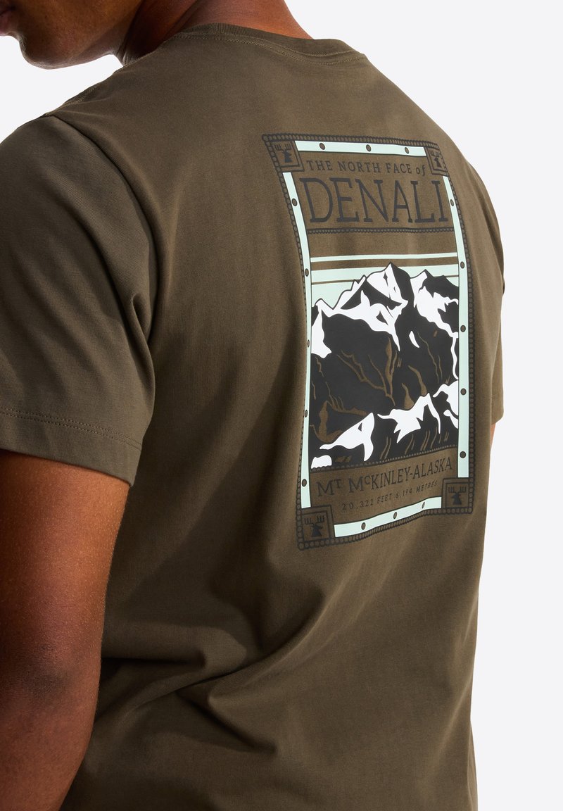 Olive green t-shirt featuring a graphic of Denali with mountains, bordered design, and text details. Made of soft cotton fabric.