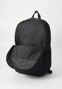 Zwarte rugzak van nylon, met een rits hoofdvak, mesh zijzakken en een handvat bovenaan voor draagbaarheid.