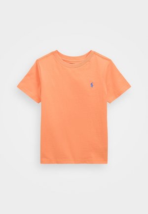 Camiseta naranja de manga corta con cuello redondo y pequeño logo azul bordado en el pecho izquierdo, mostrada sobre un fondo blanco liso.