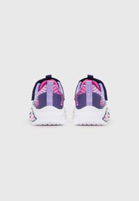 Un paio di sneaker per bambini viola e rosa con suole bianche, viste da dietro su uno sfondo chiaro e uniforme.