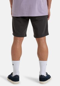 Grijze shorts gemaakt van een katoenmix, met een relaxte pasvorm en omgeslagen zoom. Gecombineerd met witte sokken en navy sneakers.