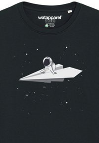 Black cotton t-shirt with a white graphic of an astronaut sitting on a paper airplane, surrounded by small stars.
