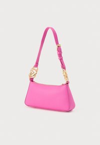 Ροζ δερμάτινη τσάντα χειρός με δομημένο τρίγωνο σχήμα, που διαθέτει κλείσιμο με φερμουάρ και χρυσούς μεταλλικούς λεπτομέρειες στο λουρί.