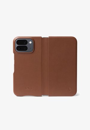 Étui folio pour téléphone en cuir marron avec découpes pour double caméra arrière et flash, avec le logo Bellroy embossé sur la couverture avant.