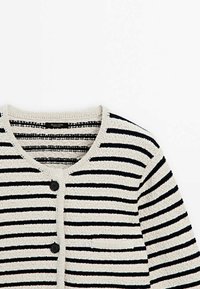 Cardigan en maille à rayures beige et noires avec encolure ronde, deux boutons noirs et une petite poche poitrine sur fond blanc.