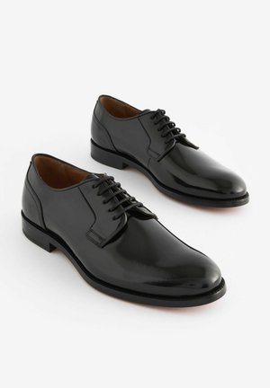 Czarne skórzane buty na dress code z polerowanym wykończeniem, okrągłym noskiem i sznurowanym zapięciem, z niskim obcasem i gładką fakturą.