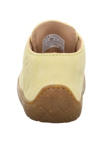 Gele suede instapper met een getextureerde bruine rubberen zool, gestikte details en een gladde voering. Voorzien van een verzorgingslabel dat aan de binnenkant is bevestigd.