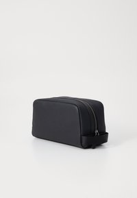 Zwarte leren cosmetica tasje met een rechthoekige vorm, dubbele ritssluiting en een zijhandvat voor een gemakkelijke grip. Textuur oppervlak met een minimalistisch ontwerp.