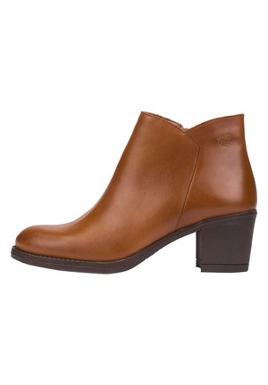 Bottine en cuir marron avec talon bloc, bout arrondi et fermeture éclair latérale, finition lisse, et un logo embossé subtil près du haut.