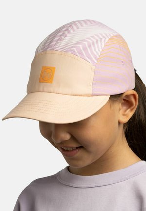 Girl wearing a pastel pink and beige patterned cap with a curved brim and orange logo patch, smiling and looking downward.