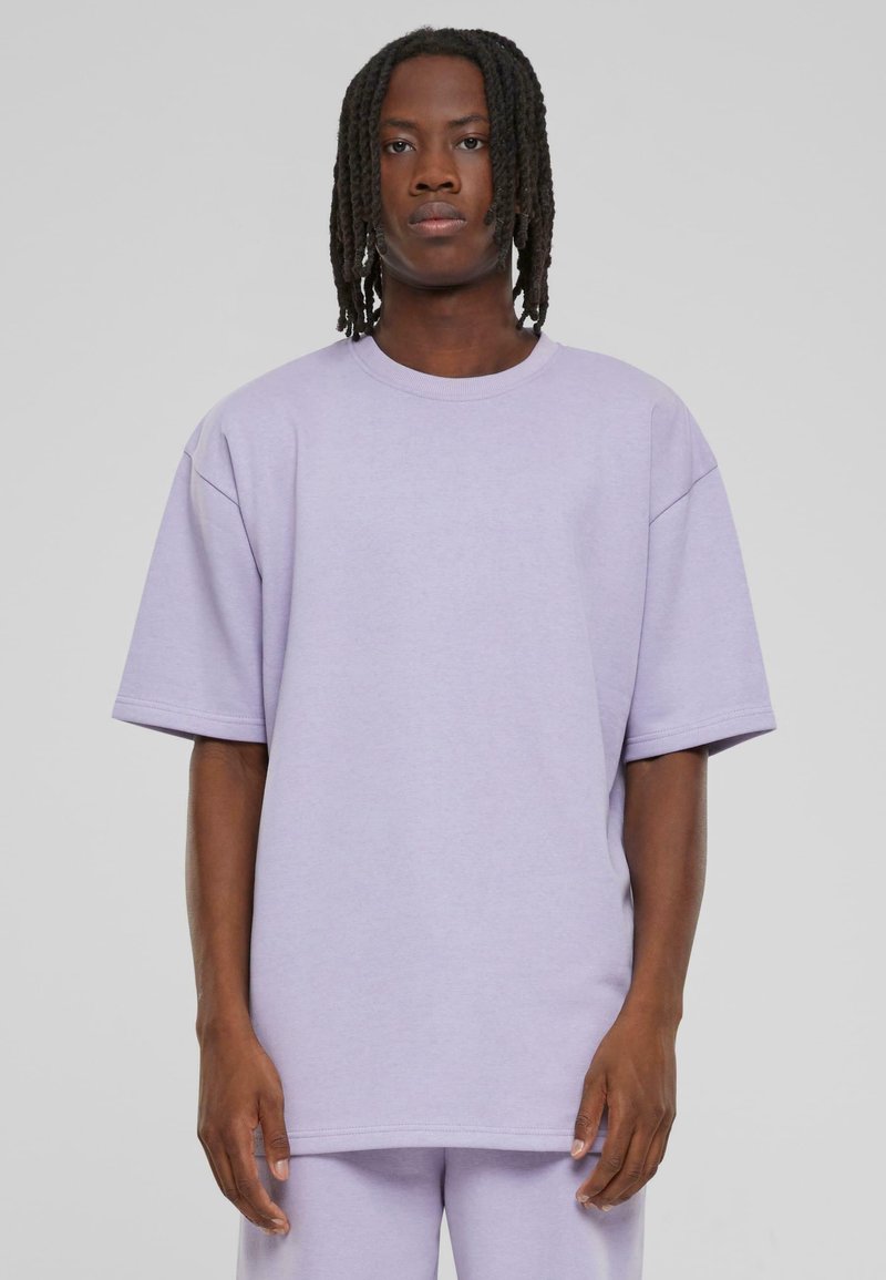 Helllila oversized T-Shirt mit kurzen Ärmeln, hergestellt aus weichem Stoff. Verfügt über einen einfachen, runden Halsausschnitt und einen entspannten Schnitt.