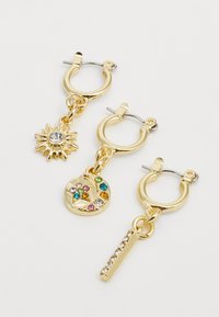 Gold hoop earrings with three distinct charms: a sun shape with a clear stone, a textured circular charm with colorful gems, and a linear design with small rhinestones.