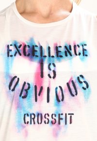Biały bawełniany t-shirt z gradientem kolorów od niebieskiego do różowego oraz czarnym napisem "EXCELLENCE IS OBVIOUS CROSSFIT". Miękka faktura.