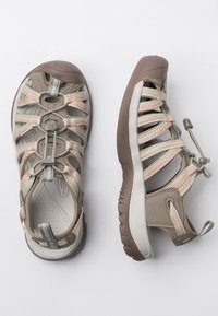 Closed-toe sandals with a tan synthetic upper, multicolored elastic straps, lightweight brown sole, and adjustable toggle for fit.