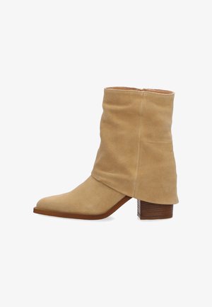 Beige ruskind ankelstøvle med løs skaft, spids snude, sides lynlås og stablet træklods hæl.