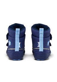 Botas infantiles de color azul marino con un exterior de tela suave, correas de velcro y una suela de goma texturizada. Presenta una pestaña trasera de color azul claro y detalles en ese mismo color.