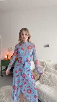 Garais piedurkņu, zilais kleitas ar rozā rakstiem ar acīm, rokām un saulēm. Aptinuma dizains ar sasietu jostasvietu un asimetrisku apakšmalu. Gluda tekstūra.