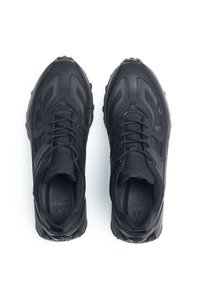 Scarpe sportive nere con una tomaia testurizzata, colletto imbottito e lacci rotondi. Presentano una suola robusta e aperture laterali per la ventilazione.
