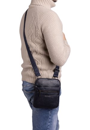 Borsa a tracolla in pelle nera con tracolla regolabile, forma rettangolare, tasca frontale con zip e dettaglio del logo in rilievo. Superficie strutturata.
