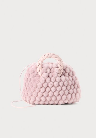 Sac à main en pompon rose texturé avec une poignée tressée et une fine sangle. Forme ronde, surface douce, design compact.