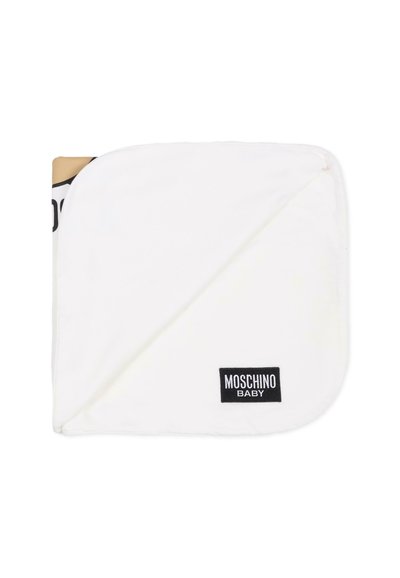 Hvid baby tæppe med et hjørne foldet tilbage, med en sort "Moschino Baby" logo label. Blød tekstur, rektangulær form, enkelt design.