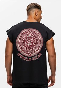 Zwarte mouwloze t-shirt met een grote rode grafiek met een gorilla-ontwerp en de tekst "GORILLA WEAR" in een cirkel op de achterkant.