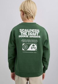 Sudadera verde oscuro con un texto blanco audaz en la espalda: "SCALPERS THE DRAFT ROOKIE AWARDS", gráficos de baloncesto y detalles de calaveras.