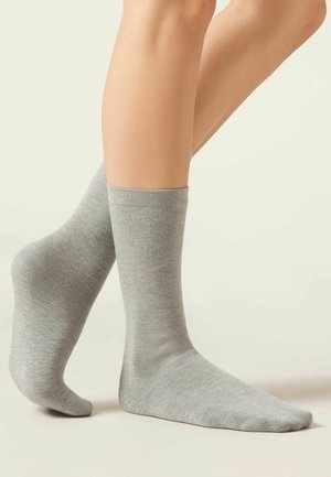 Grå bomuldsstrømper med et simpelt design, midt-lægs længde og glat tekstur, der viser en tætsiddende kant øverst.