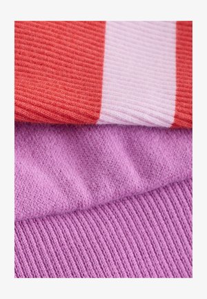 Strickstoff in drei Schichten: ein korallenfarbener gerippter Abschnitt, ein hellrosa gestreifter Abschnitt und ein weicher lavendelfarbener, strukturierter Abschnitt darunter.