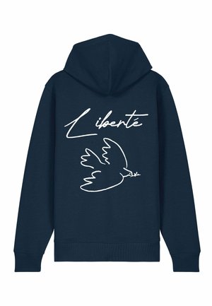 Sötétkék kapucnis póló, fehér vonalrajz egy galambbal és a "Liberté" felirattal a hátsó részén. Puha tapintású és laza fazon.