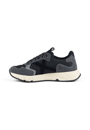 Sneaker nera e grigio scuro con dettagli in suede, suola bianca e chiusura con lacci, mostrata dal lato interno su sfondo bianco.