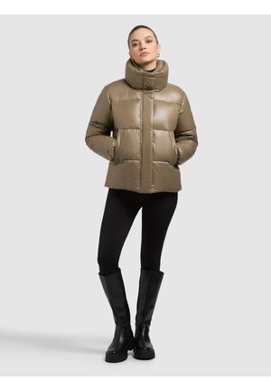 Giacca imbottita verde oliva, con collo alto, design trapuntato e due tasche frontali. Abbinata a leggings neri e stivali al ginocchio.