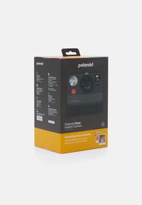 Polaroid Now Instant Camera packaging features a black cardboard box with a top handle, multicolored accents, and product details on the sides.