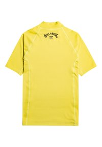 Lyhythihainen keltainen rash guard, jossa on litteät saumat, korkea kaulus ja painettu logo selässä. Sileä, joustava kangas vesitoimintaan.