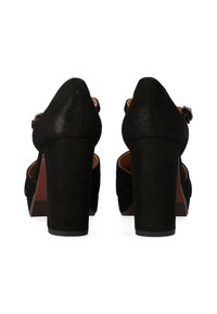 Scarpe nere con tacco alto con una finitura in tessuto texturizzato simile al suede. Parte posteriore chiusa, cinturino alla caviglia regolabile e tacchi a piattaforma chunky.