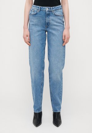 Lyseblå høyhårede jeans med rett snitt, med glidelås, fem lomme-design og minimal slitasje, kombinert med svarte hæler.