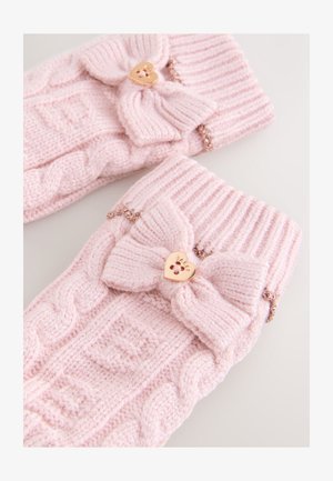 Muffole lavorate a maglia di colore rosa pallido con polsino a coste, caratterizzate da un grande fiocco e da una chiusura dorata a forma di cuore con dettaglio traforato a tema floreale.