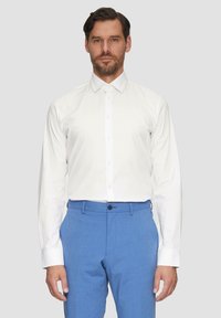 Witte langemouwen overhemd met een spread collar, gecombineerd met lichtblauwe tailor-made broek, met een soepel textuur en een flat front ontwerp.