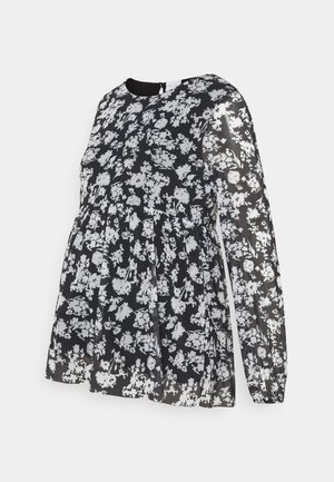 Czarna i biała bluzka w kwiaty z długim rękawem, okrągłym dekoltem i zmarszczoną talią, co zapewnia luźny krój. Przezroczysty materiał.