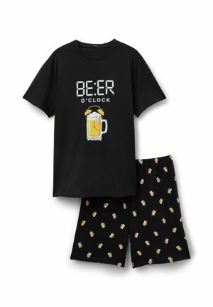 Ensemble chemise noire à manches courtes et short avec imprimés jaunes de chopes de bière ; le texte sur la chemise indique « BEER O'CLOCK » avec un graphique d'horloge réveil en forme de chope de bière.