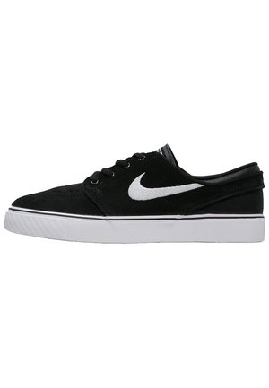Sort lav sneaker med hvid Nike swoosh-logo og hvid sål, med sorte snørebånd og polstret krave.