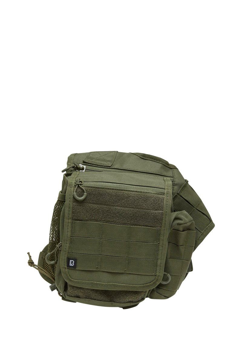 Grön taktisk väska tillverkad av hållbart material, utrustad med flera fickor med dragkedja, nätficka och remmar för fäste.