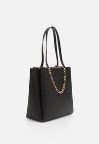 Czarna skórzana torba typu tote o teksturowanym wykończeniu, z podwójnymi długimi ramiączkami i złotym akcentem w postaci łańcucha. Strukturalny kształt z otwartym szczytem.