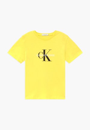 Camiseta amarilla de manga corta con cuello redondo con el logo "cK" en negro y "Calvin Klein Jeans" en blanco impreso en el pecho.