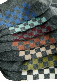 Wollsocken in verschiedenen Grautönen und bunten Schachbrettmustern: Blau, Teal, Burgunder, Rost, Beige und grüne Akzente.