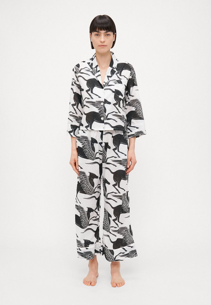 Πυτζάμα με σχέδιο που διαθέτει μαύρα και λευκά ζώα. Περιλαμβάνει μακρυμάνικο πουκάμισο με κουμπιά και φαρδιά παντελόνια. Ελαφρύ ύφασμα.
