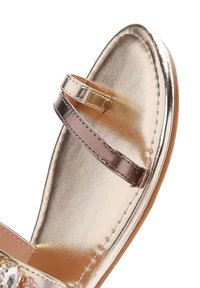 Sandal in oro metallico con una cintura stretta, caratterizzata da una texture liscia e da strass decorativi in tonalità di rosa e trasparente.