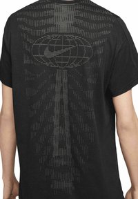 Maglietta nera in cotone con un design testurizzato e pixelato sul retro, che somiglia a un motivo grafico in diverse sfumature di grigio.