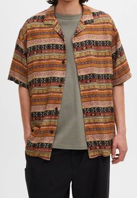 Kortærmet skjorte med et mønstret multicolor design i jordfarver som orange, grøn og sort, samt en afslappet krave.